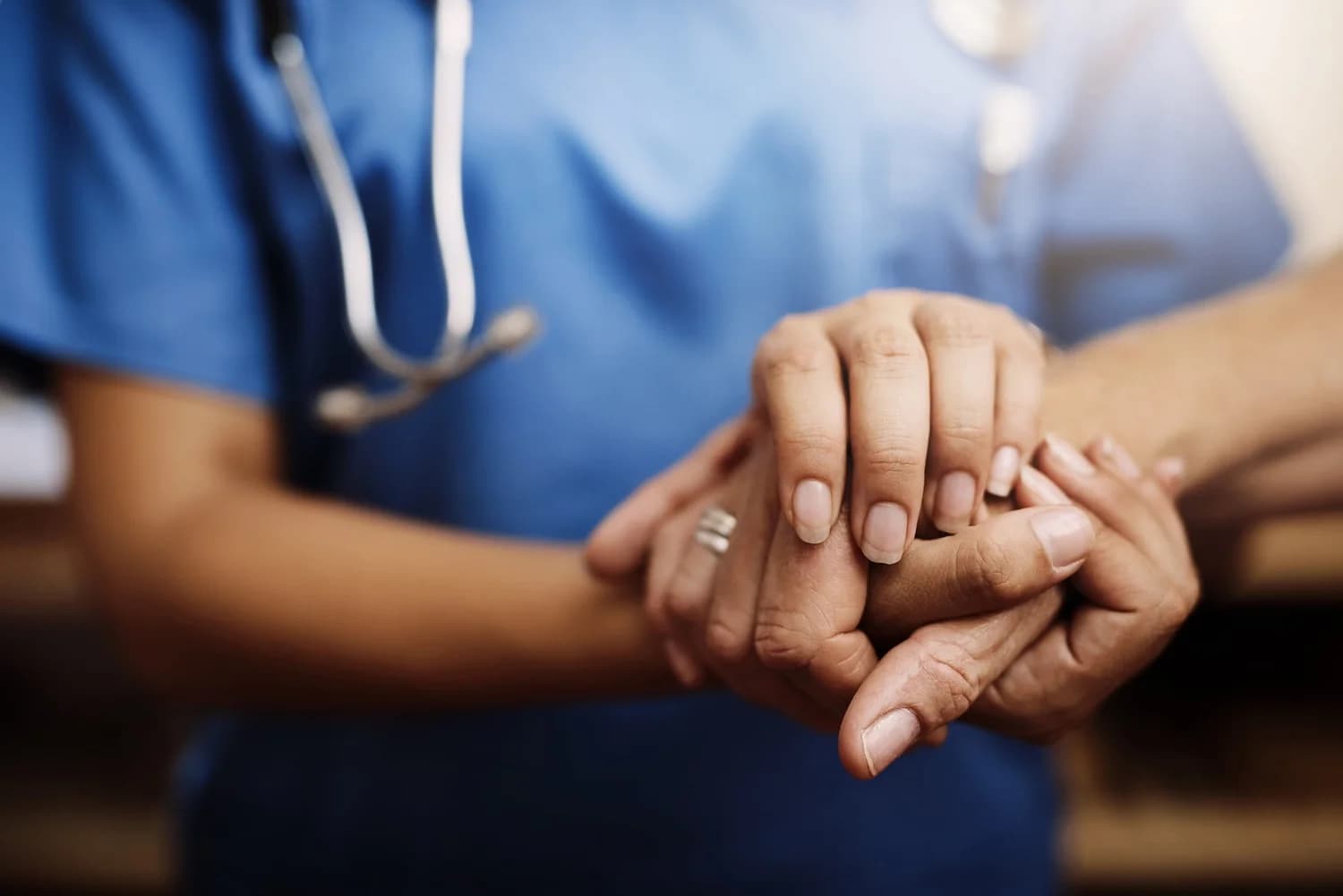 A healthcare professional offering a reassuring hand to a patient